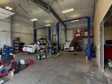 Inside the bays at That JDM Shop, a car up on the two-post lift